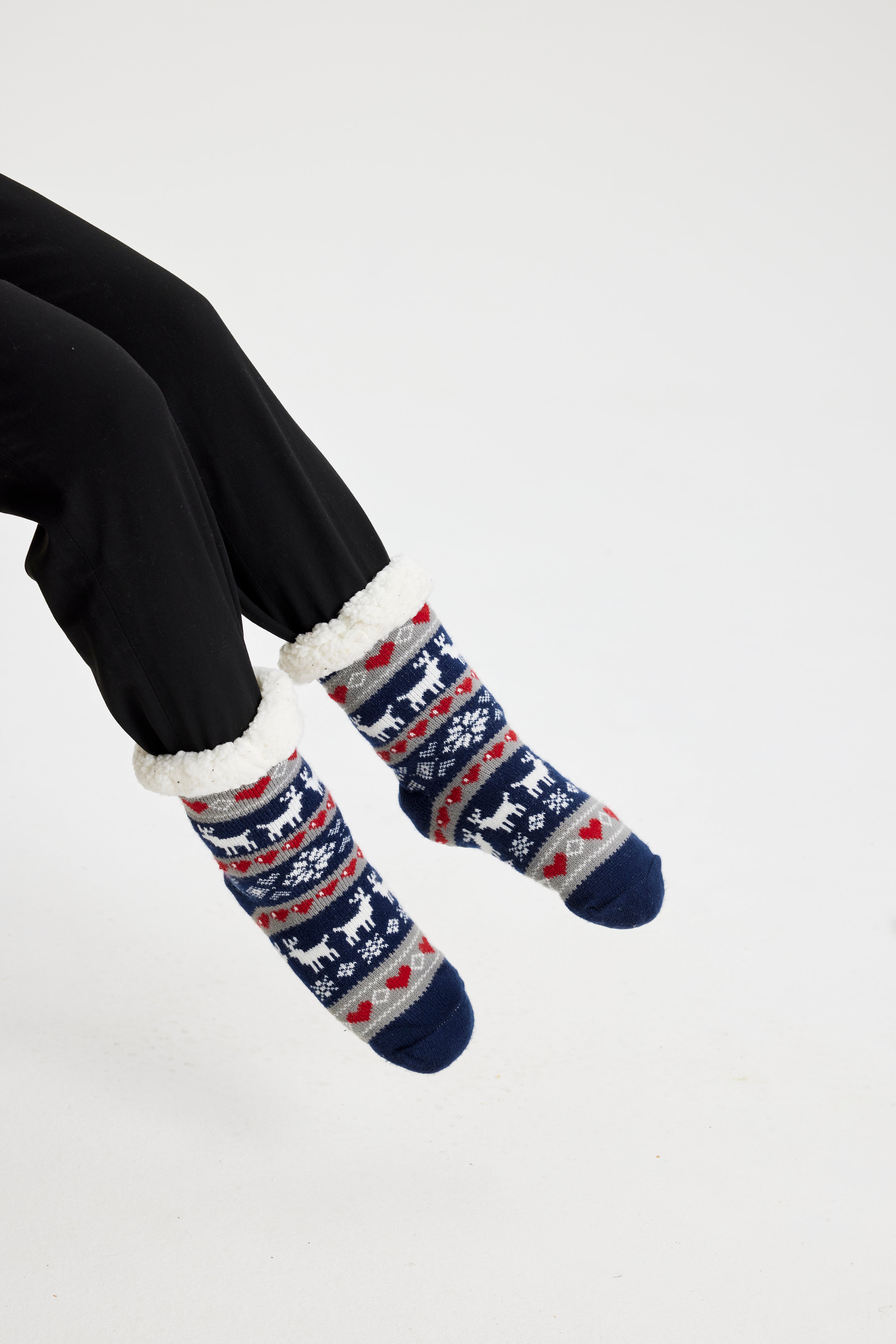 Un paio di piedi con calzini di Natale bianchi e blu.